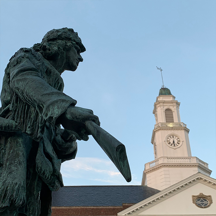 Bronze statue in front of a clock tower